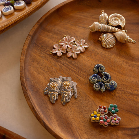 Wooden tray with decorative jewelry pieces on a beige surface